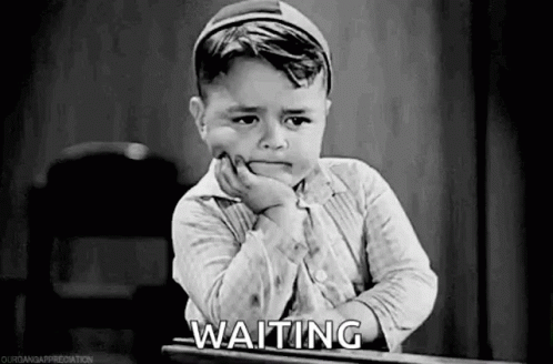 A Little Boy Is Sitting At A Desk And Waiting . GIF