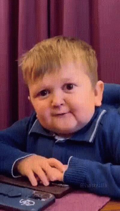 A Little Boy Is Sitting At A Table Using A Computer Keyboard . GIF