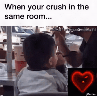 A Little Boy Is Sitting At A Table With A Man Taking A Picture Of Him With A Cell Phone .. GIF