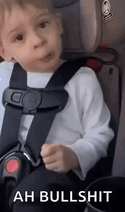 A Little Boy Is Sitting In A Car Seat And Making A Face . GIF