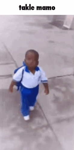 A Little Boy Is Walking Down A Sidewalk With A Backpack On His Back . GIF
