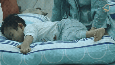 A Little Boy Laying On A Pillow With The Word Home On The Bottom Right GIF