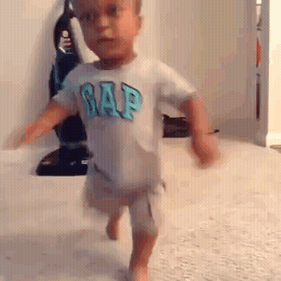 A Little Boy Wearing A Gap Shirt Is Running On The Floor . GIF