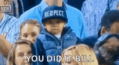 A Little Boy Wearing A Hat That Says Respect Is Sitting In A Crowd Of People . GIF