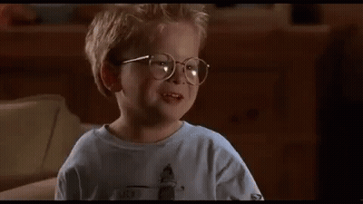 A Little Boy Wearing Glasses Is Sitting On A Couch And Saying `` The Human Head Weighs Eight Pounds '' . GIF