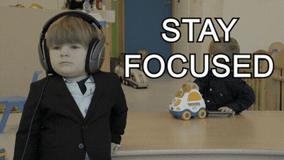 A Little Boy Wearing Headphones With The Words Stay Focused Above Him GIF