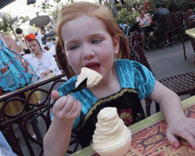 A Little Girl Eating Ice Cream With A Spoon GIF