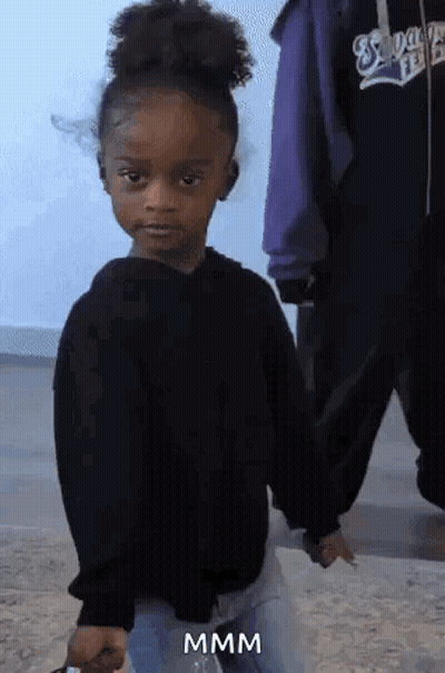 A Little Girl In A Black Sweater Is Holding Someone 'S Hand And Making A Funny Face .. GIF