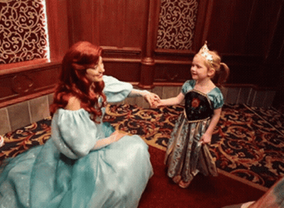 A Little Girl In A Blue Dress Is Holding Hands With A Princess GIF