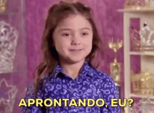 A Little Girl In A Blue Shirt Is Standing In Front Of A Shelf With Trophies And A Purple Wall . GIF