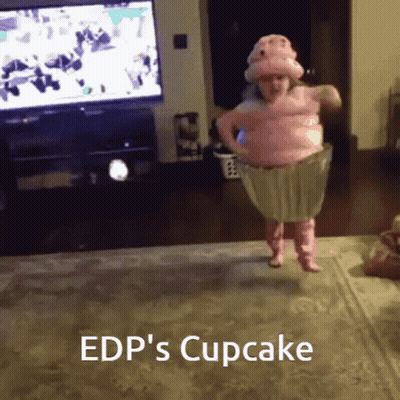 A Little Girl In A Pink Cupcake Costume Is Jumping In The Air GIF