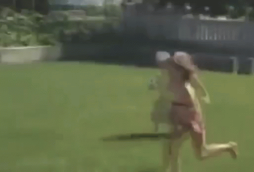 A Little Girl In A Pink Dress Is Jumping Into A Swimming Pool GIF
