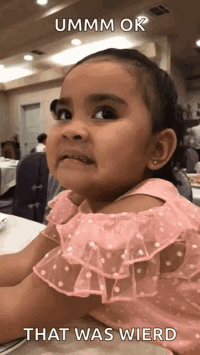 A Little Girl In A Pink Dress Is Sitting At A Table With A Caption That Says That Was Wierd . GIF