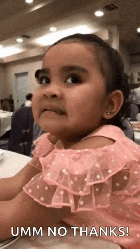 A Little Girl In A Pink Dress Is Sitting At A Table With The Words Umm No Thanks Written Below Her . GIF
