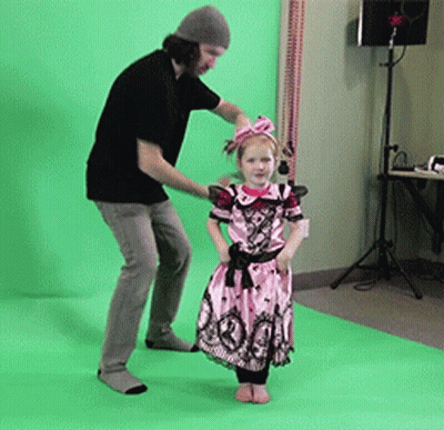 A Little Girl In A Pink Dress Is Standing Next To A Man GIF