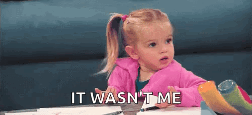 A Little Girl In A Pink Jacket Is Sitting At A Table With A Marker And The Words `` It Wasn 'T Me '' . GIF