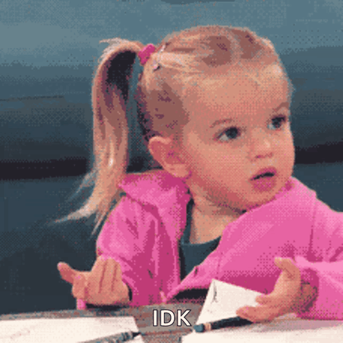 A Little Girl In A Pink Jacket Is Sitting At A Table With A Pencil In Her Hand And The Words Idk Above Her GIF