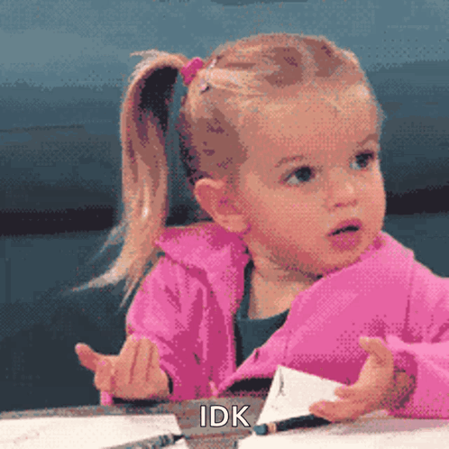 A Little Girl In A Pink Jacket Is Sitting At A Table With A Pencil In Her Hand And The Words Idk Above Her GIF