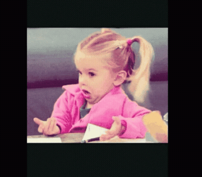 A Little Girl In A Pink Jacket Sitting At A Table GIF