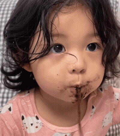 A Little Girl In A Pink Shirt With Cats On It GIF