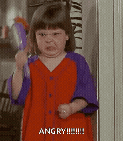 A Little Girl In A Red And Purple Dress Is Brushing Her Hair . GIF