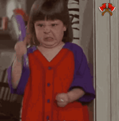 A Little Girl In A Red And Purple Shirt Is Holding A Purple Object And Saying Hushh GIF