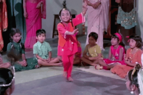 A Little Girl In A Red Dress Is Dancing In Front Of A Crowd Of Children GIF