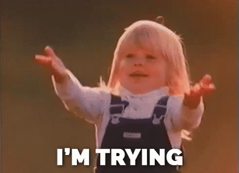 A Little Girl In Overalls Is Standing With Her Arms Outstretched And Saying `` I 'M Trying '' . GIF