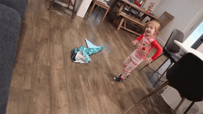 A Little Girl In Pajamas Standing On A Wood Floor GIF