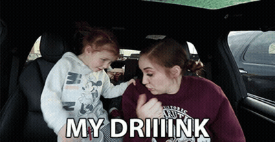 A Little Girl Is Being Held By A Woman In A Car And The Words My Driiink Are Above Them GIF