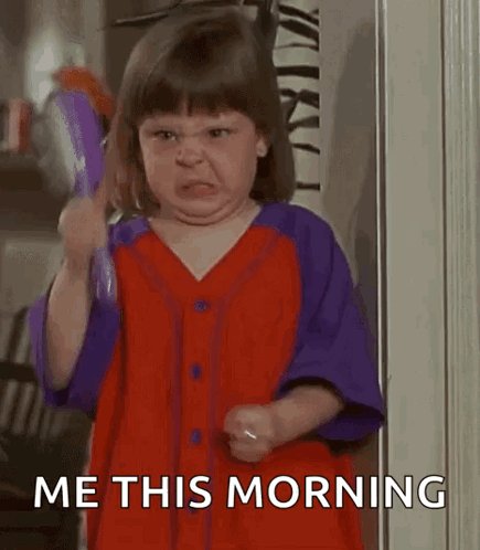 A Little Girl Is Brushing Her Hair With A Brush And Making A Face . GIF