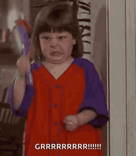 A Little Girl Is Brushing Her Teeth With A Toothbrush And Making A Face . GIF