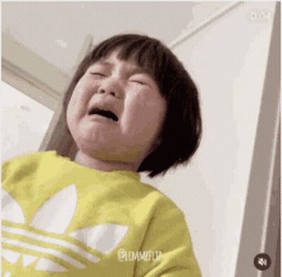 A Little Girl Is Crying And Wearing A Yellow Adidas Sweatshirt . GIF