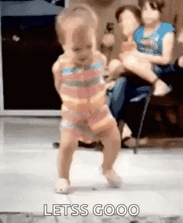 Girl Dancing On Floor Woman Holds Baby GIF