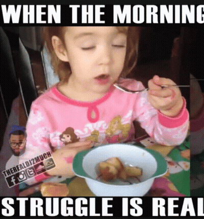A Little Girl Is Eating A Bowl Of Cereal With A Spoon .. GIF
