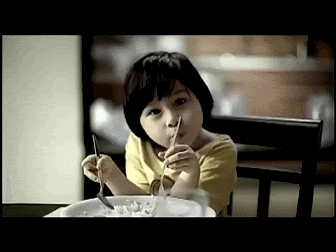 A Little Girl Is Eating Cereal With A Fork GIF