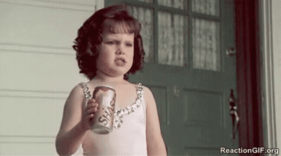 A Little Girl Is Holding A Can Of Soda And Making A Face . GIF