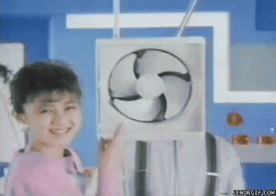 A Little Girl Is Holding A Fan In Front Of Her Face And Smiling . GIF