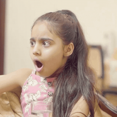 A Little Girl Is Holding A Glass Of Water With Her Mouth Open GIF