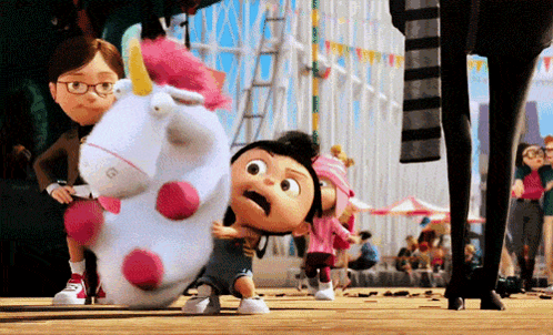A Little Girl Is Holding A Stuffed Unicorn With The Letter G On Its Head GIF
