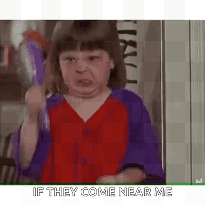 A Little Girl Is Holding A Toothbrush And Making A Face . GIF