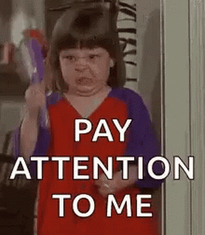 A Little Girl Is Holding A Toy And Making A Funny Face And Says `` Pay Attention To Me '' . GIF