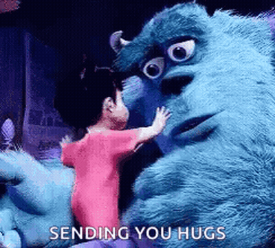A Little Girl Is Hugging A Stuffed Animal From Monsters Inc . GIF