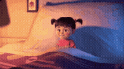 A Little Girl Is Laying In A Bed With A Blue Blanket And A Picture On The Wall . GIF