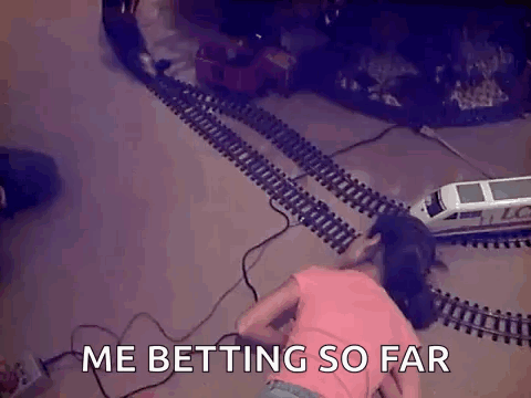A Little Girl Is Laying On The Floor Playing With A Toy Train Set And Says Me Betting So Far GIF