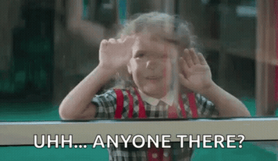 A Little Girl Is Looking Out Of A Window And Making A Funny Face With Her Hands . GIF