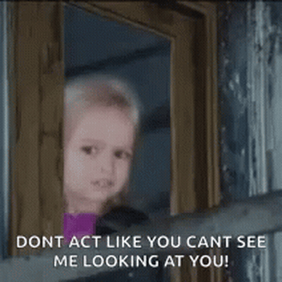 A Little Girl Is Looking Out Of A Window With The Words `` Dont Act Like You Cant See Me Looking At You '' . GIF
