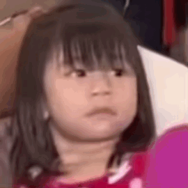 A Little Girl Is Making A Funny Face While Looking At A Cell Phone . GIF