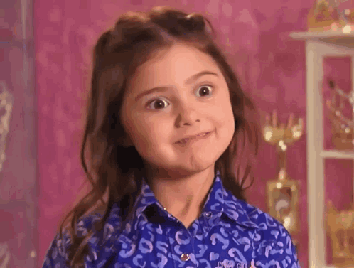 A Little Girl Is Making A Funny Face While Wearing A Blue Shirt With A Leopard Print . GIF