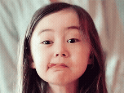 A Little Girl Is Making A Funny Face With Her Tongue Out GIF
